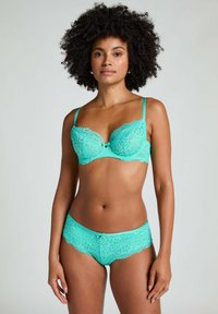 Turquoise kantenzonder beha met beugel en verstelbare bandjes, gecombineerd met bijpassende kantenen slip. Bloemenpatroon en een klein strikdetail aan de voorkant.