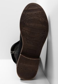 Czarny sznurowany botek zamszowy z teksturowaną gumową podeszwą, wyposażony w boczny zamek błyskawiczny i ozdobne przeszycia. Rozmiar 37 widoczny na podeszwie.