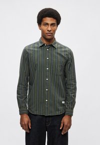 Koszula na guziki z długim rękawem w zielono-niebieskie paski z kieszenią. Miękka w dotyku, gładka tkanina i klasyczny kołnierz.