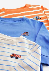 Tre bomulds t-shirts. Orange og hvidstribet; blå ensfarvet; cremefarvet med blå striber. Hver t-shirt har et broderet køretøjsdesign.