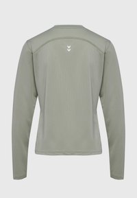 Langärmliges Hemd aus hellgrünem Stoff mit strukturierter Oberfläche, runder Halslinie und minimalistischer weißer Logodetail auf der Rückseite.