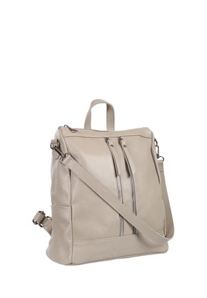 Beige leren rugzak met twee verticale frontzakken met rits en een verstelbare schouderband op een witte achtergrond.