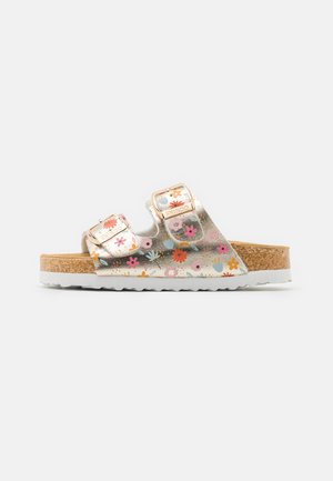 Chinelas deslizantes com um upper estampado metálico floral, dois fivelas ajustáveis, palmilha de cortiça e sola de borracha branca.