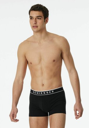 Black boxer briefs with a white branded waistband. Made from a stretchy cotton blend, featuring a snug fit and smooth texture.