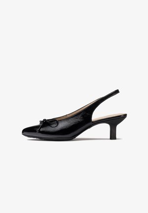 Escarpins ouverts à l'arrière en cuir verni noir avec un bout pointu, ornés d'un nœud et d'un talon bas et épais. Texture lisse, design élégant.