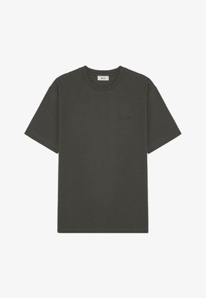 Mörkgrön bomulls t-shirt med korta ärmar, rund halsringning och subtilt präglad logotypdetalj på bröstet. Klassisk passform och slät textur.