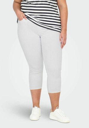 Lysgrå capri leggings lavet af strækbart materiale, der har en glat overflade og tætsiddende design. Bæret med en blåt-hvid stribet top.