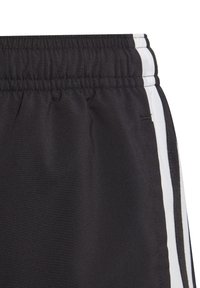 Schwarze Sportshorts aus strukturiertem Stoff, mit elastischem Bund und weißen Seitestreifen für einen Kontrast. Einfaches Design und praktische Passform.