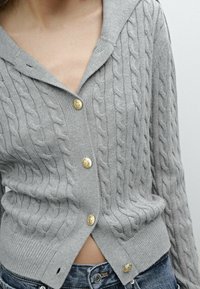 Gray cable-knit cardigan with a hood, featuring gold buttons and a cropped hem. Textured fabric with a ribbed border at the waist.