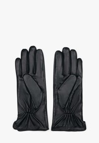 Een paar zwarte leren handschoenen met elastische polsen, plat naast elkaar gelegd, vingers gestrekt.