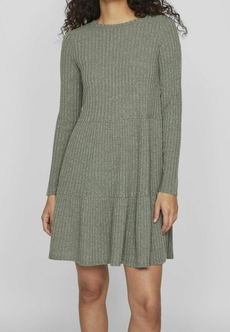 Robe à manches longues en maille côtelée de couleur vert olive, avec un col rond et un ourlet évasé à volants, confectionnée dans un tissu tricoté doux.