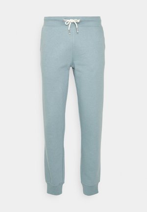Light blue sweatpants made from soft material, featuring a drawstring waist with silver hardware and fitted cuffs at the ankles.