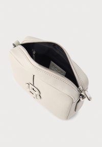 Svetlosivá kožená púzdro na zips s textúrovaným povrchom a vytlačeným logom. Má kontrastnú čiernu vnútornú výbavu a strieborné kovanie.