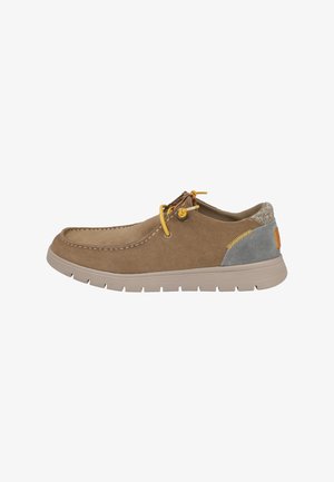 Zapato casual de ante marrón con cordones amarillos, suela beige clara, parche gris en el talón y costuras visibles alrededor de la puntera y los laterales.