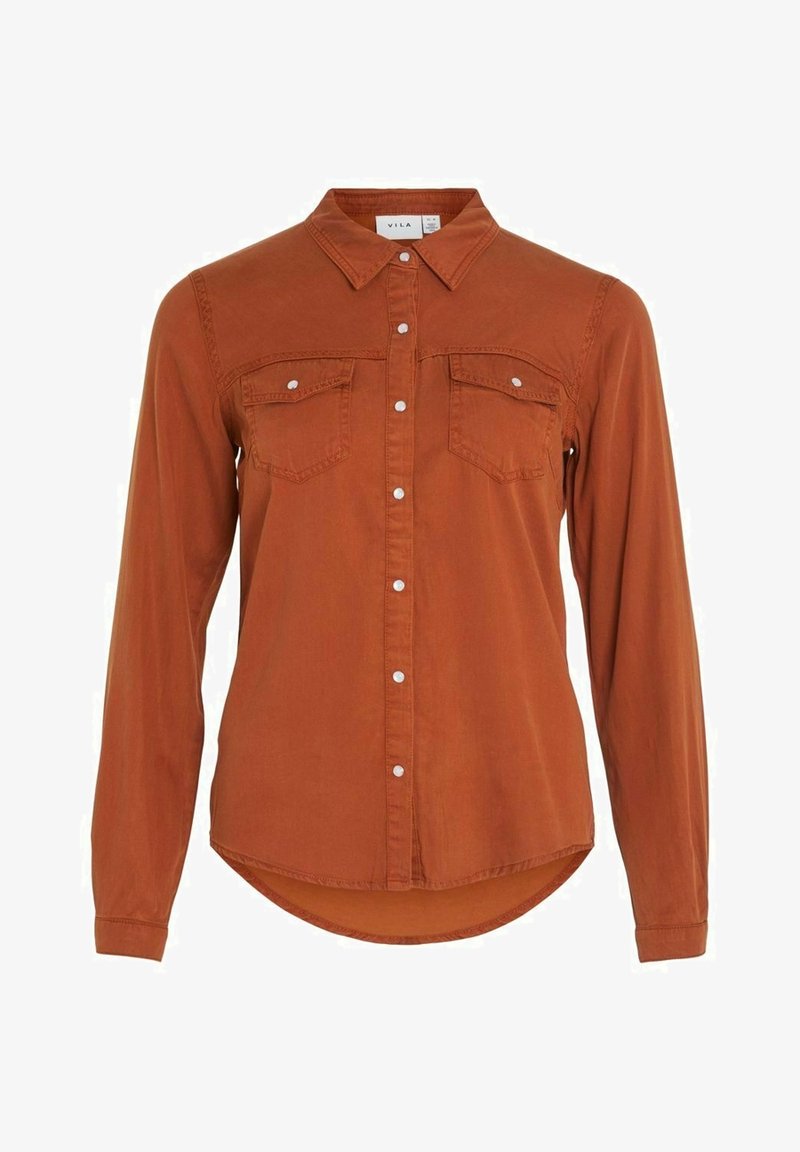 Chemise à manches longues couleur rouille avec col et deux poches poitrine, dotée de boutons-pression blancs et d'un ourlet légèrement arrondi.