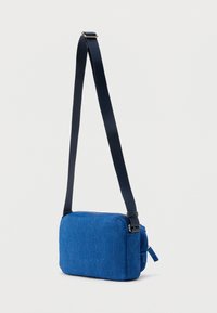 Μπλε τσάντα χιαστί από υφή ύφασμα, με ορθογώνιο σχήμα, κλείσιμο με φερμουάρ και ρυθμιζόμενο λουράκι.