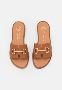 Brune slidesandaler med en struktureret læderoverdel, der har en gylden kædeaccent og åbent tådesign. Tan indersål med brandlogo.