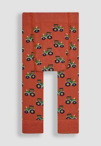 Piros leggings zöld és kék traktorok ismétlődő mintázatával, fehér díszítésekkel. Az anyag sima és elasztikus.