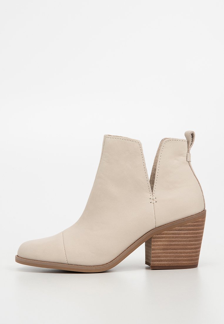 Beige Leder-Stiefelette mit spitzem Zehenbereich, elastischen Seiteneinsätzen und einem gestapelten Blockabsatz mit horizontalen Rillen.