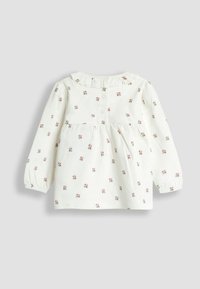 Biele dlhé rukávy detská šaty s malou ružovou kvetinovou potlačou, gombíky na chrbte a jemne volánkovým golierom.