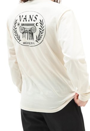 Crème langemouwen T-shirt gemaakt van zachte stof met een zwart grafisch logo op de achterkant, inclusief een kolomontwerp en lauriertak.