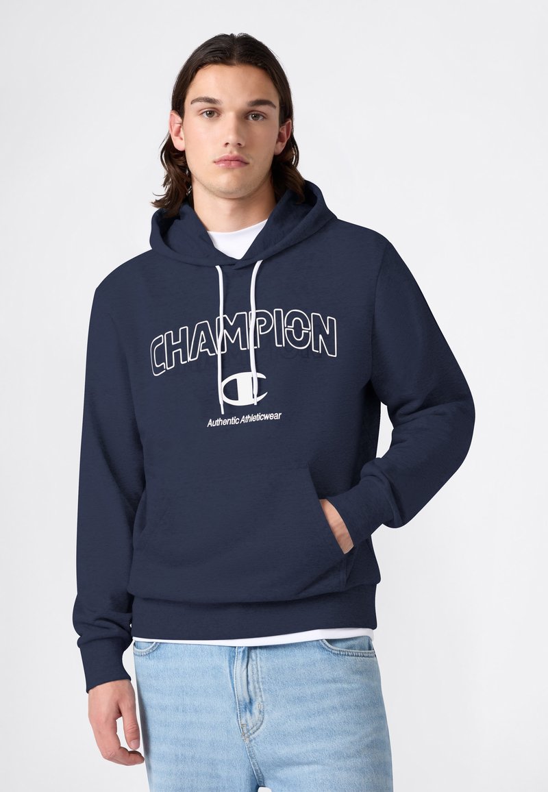 Sweat à capuche bleu marine avec logo "CHAMPION" blanc et texte "Authentic Athleticwear". Comprend une capuche à cordon de serrage et une poche kangourou avant.
