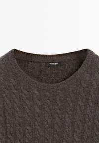Pull en maille torsadée gris foncé avec un col rond et une étiquette Massimo Dutti à l'intérieur du col, fabriqué en Chine.
