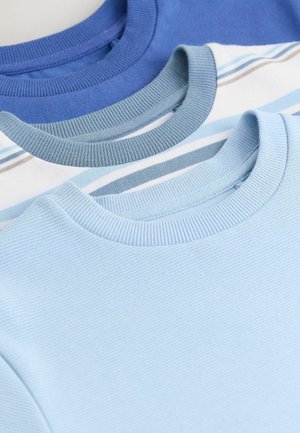 Drie T-shirts in verschillende tinten blauw: een effen donkerblauwe, een lichtblauwe met horizontale strepen en een effen zachte blauwe. Allemaal met ribgebreide kraag.