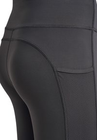 Svarta atletiska leggings med en smidig tygkvalitet och en meshpanel på sidan. De har förstärkta sömmar och en åtsittande design.