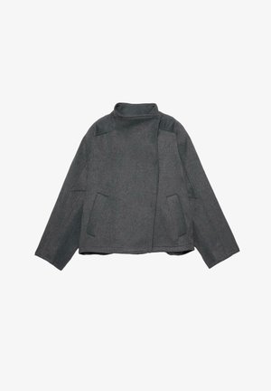 Giacca di lana grigia con collo alto, maniche larghe e due tasche frontali. Il tessuto appare strutturato, offrendo un design minimalista e definito.