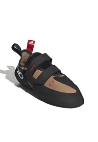 Crne planinarske cipele s smešnim nubuk nožnim kutijama. Imaju dva čičak traka, Adidas logo i gumeni potplat dizajniran za prianjanje.