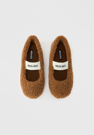 Paire de chaussons marron pelucheux à enfiler avec des bandes élastiques blanches portant l'inscription "MOON BOOT" sur un fond blanc uni.