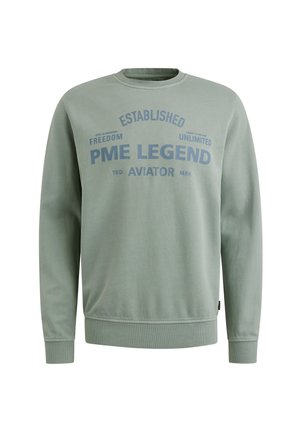 Sweatshirt vert avec col rond, poignets et ourlet côtelés. Présente un grand texte bleu : "PME LEGEND ESTABLISHED AVIATOR" ainsi que d'autres phrases.
