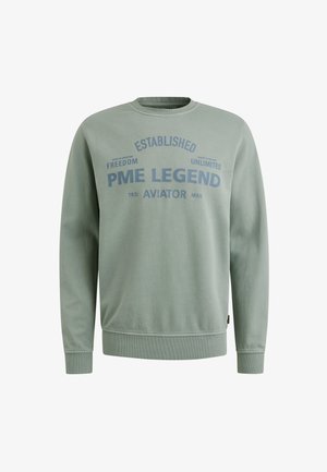 Sudadera verde con cuello redondo, puños y dobladillo acanalados. Presenta un gran texto azul: "PME LEGEND ESTABLISHED AVIATOR" y frases adicionales.