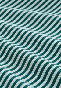 Textile with a repeating wave pattern in teal and white. The fabric has a ribbed texture, showcasing alternating thick and thin stripes.