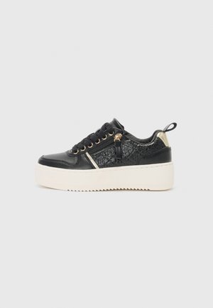 Fekete platform sportcipők texturált bőrből, arany kiegészítőkkel és fehér gumitalppal. Fűzős kialakítással és díszes oldalsó cipzárral rendelkezik.