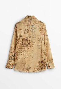 Chemise beige à manches longues avec des motifs floraux et abstraits en marron et vert doux, vue de dos sur fond blanc.