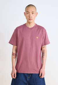 Maroon cotton t-shirt with a round neckline, short sleeves, and a small yellow logo on the chest. Soft texture, relaxed fit.