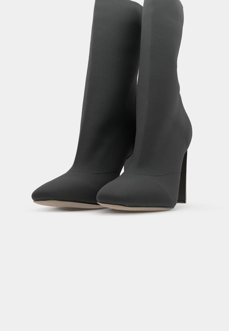 Schwarze Knöchelboots mit kitten-heel aus glattem Stoff, mit einer spitzen Zehenform und nahtlosem Design, sowie einem hohen Stiletto-Absatz.