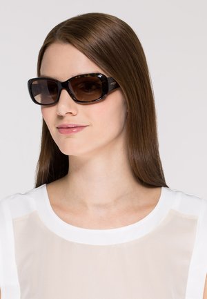 Ochelari de soare cu o ramă din broscuță țestoasă închisă și lentile maro cu gradienți. Textură netedă și formă rectangulară, cu branding subtil pe lateral.