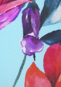 Blumenstoff mit lebhaften lila und roten Blütenblättern auf einem hellblauen Hintergrund; textile Struktur sichtbar, mit detaillierten Mustern und Schattierungen.
