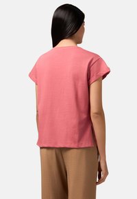 Roze, korte mouwen t-shirt van zacht katoen. Ronde halslijn met opgerolde mouwen, zijsplitten en een relaxte pasvorm. Casual ontwerp.