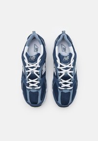 Zapatillas de correr en azul marino y claro con parte superior de malla, cordones blancos y collar acolchado. Presentan un logo en contraste en el costado.