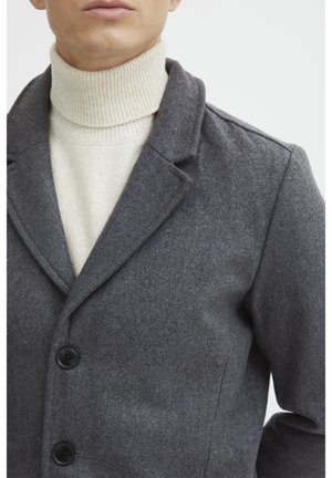 Manteau en mélange de laine gris avec un col à revers, trois boutons noirs, et un doux col roulé crème en dessous, présenté sur un fond uni.