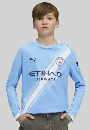 Ilgaamžių šviesiai mėlynas futbolo marškinėliai su balta įstrižine juosta, Puma logotipas, Mančesterio miesto herbas ir tamsiai mėlynas tekstas "ETIHAD AIRWAYS".