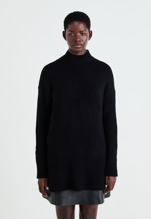 Maglione nero lavorato a maglia con collo alto, maniche lunghe e vestibilità rilassata, caratterizzato da costine testurizzate in tutto il capo.