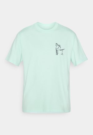 Camiseta de algodón verde menta de manga corta. Cuenta con una pequeña ilustración gráfica negra en el lado izquierdo del pecho. Diseño estándar de cuello redondo.