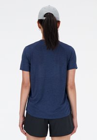 Σκούρο μπλε αθλητικό μπλουζάκι κοντό μανίκι με υφή και ράγκλαν μανίκια, συνδυασμένο με μαύρες αθλητικές σορτσάτες.