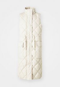 Colete puffer longo e sem mangas em bege claro, com padrão de quilt em losangos, colarinho alto, fecho de botão de pressão, duas bolsos frontais e cintura ajustável com cordão.