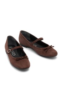 Brown suede ballet flats with a rounded toe, a small heel, and a decorative bow on the front. Includes an adjustable strap with a buckle.